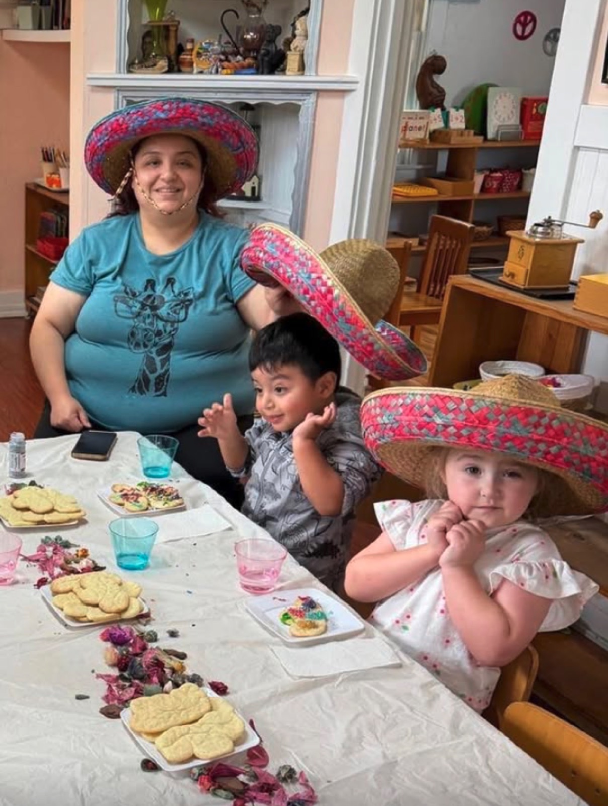 A family decorates cookies together in sombreros at our fiesta morning