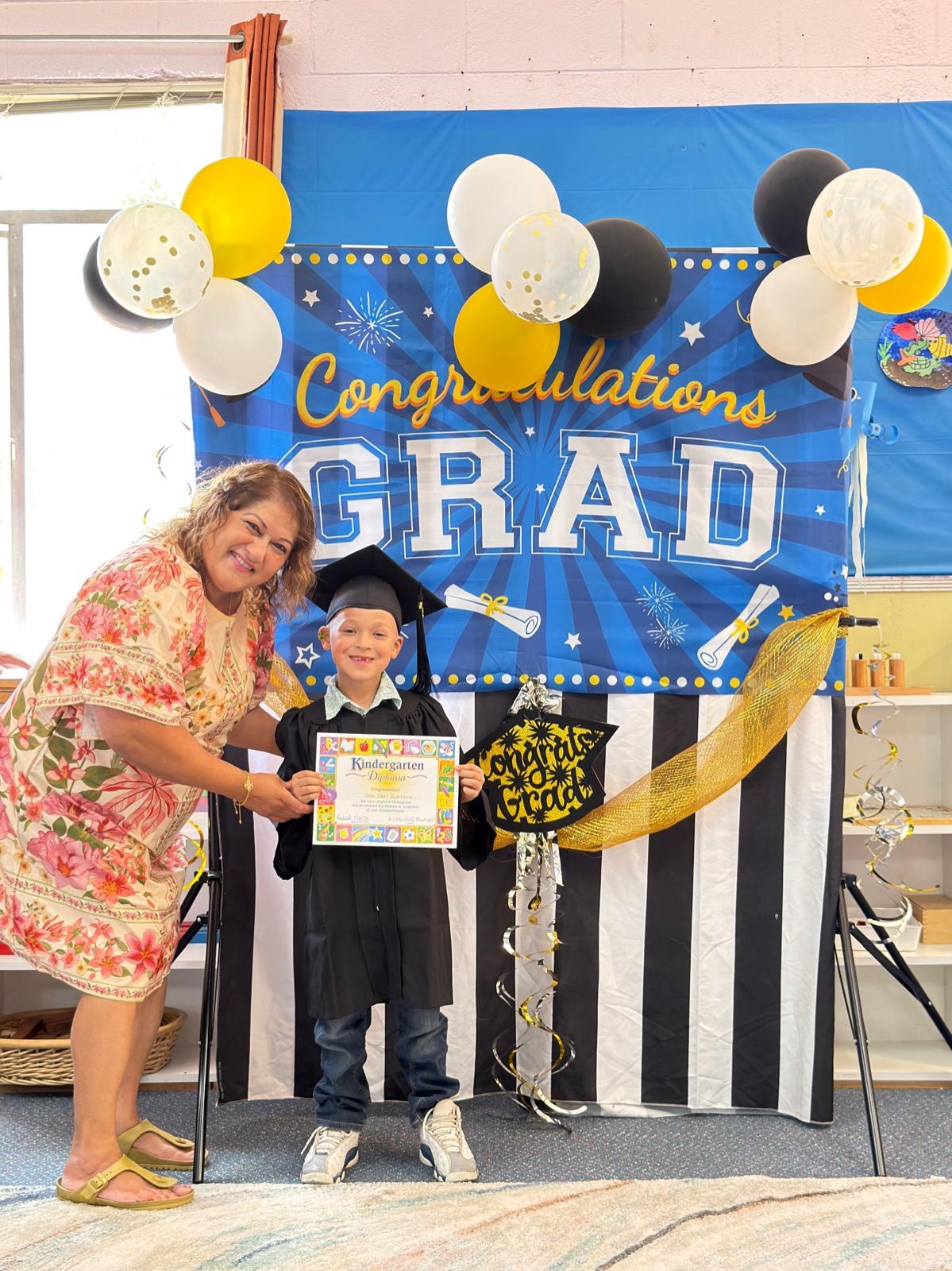 Director Samudra presents a kindergarten certificate to a proud graduate